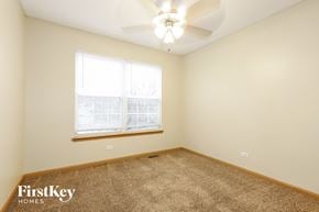 Huntley house for rent - a bedroom with a ceiling fan and a window