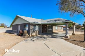 Peoria house for rent - A house with a grey roof and a white fence is for sale.