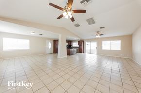 Peoria house for rent - A spacious room with a ceiling fan and tiled flooring.