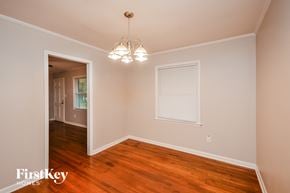 Covington house for rent - a bedroom with hardwood flooring and a door to a hallway with a window