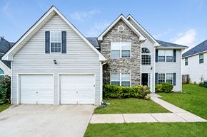 Hampton house for rent - a white house with a white garage door and a lawn