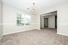Hampton house for rent - an empty living room with a large window and carpeting