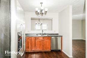 Greenwood house for rent - a kitchen with wooden cabinets and a sink and a refrigerator