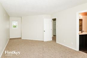 Greenwood house for rent - a bedroom with a door to a bathroom and a sink