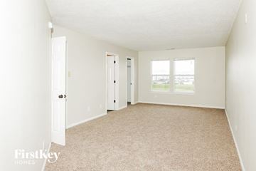 Greenwood house for rent - a spacious living room with white walls and carpet