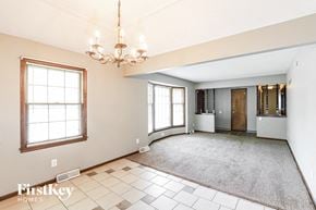 Kansas City house for rent - A large, empty room with a chandelier and a rug on the floor.