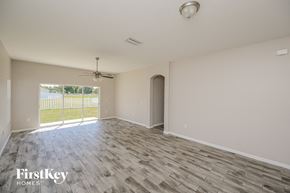 Gibsonton house for rent - A room with a ceiling fan and sliding glass doors.
