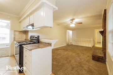 Kansas City house for rent - A kitchen with a stove top oven and a ceiling fan.