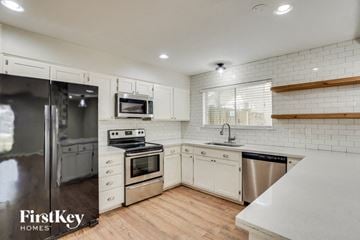 Spring house for rent - A kitchen with white cabinets and a stainless steel dishwasher.