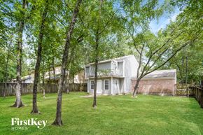 Spring house for rent - A white house with a fence and trees in the yard.
