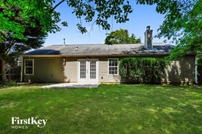 Lawrenceville house for rent - a small yellow house with white doors and a grassy yard