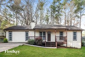 Acworth house for rent - a small white house with a porch and a lawn
