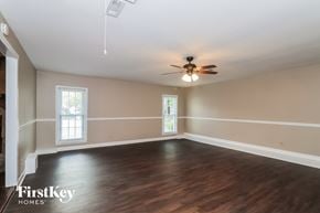 Acworth house for rent - an empty living room with wood floors and a ceiling fan