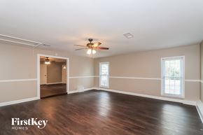 Acworth house for rent - an empty living room with wood floors and a ceiling fan