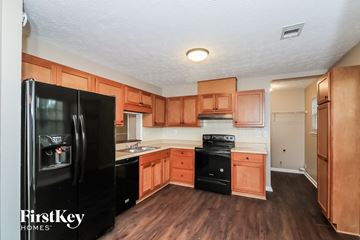 Acworth house for rent - a kitchen with black appliances and wooden cabinets