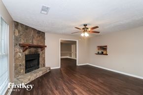 Acworth house for rent - a living room with a stone fireplace and a ceiling fan