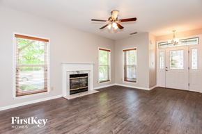 Charlotte house for rent - an empty living room with a fireplace and a ceiling fan