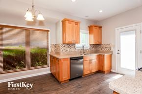 Charlotte house for rent - a kitchen with wooden cabinets and a dishwasher and a window