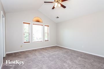 Charlotte house for rent - a living room with carpet and a ceiling fan