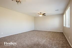 Peoria house for rent - A room with a carpeted floor and a ceiling fan.
