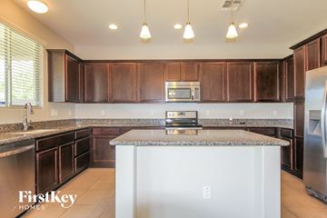 Peoria house for rent - A kitchen with brown cabinets and a white island.