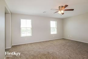 Peoria house for rent - A spacious room with a ceiling fan and two windows.