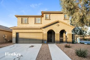Peoria house for rent - A beige house with a garage door and a driveway.