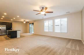Peoria house for rent - A spacious room with a ceiling fan and carpeted floor.