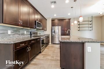 Peoria house for rent - a kitchen with granite counter tops and wooden cabinets