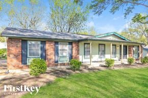 Florissant house for rent - A brick house with a green roof and a sign that says "Firstkey Homes".