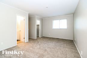 Florissant house for rent - A spacious room with a carpeted floor and a window.