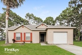 Sebastian house for rent - A house with a red window and a white garage door is for sale.