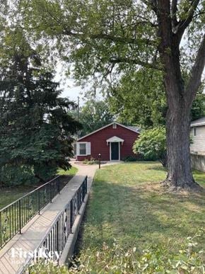 Joliet house for rent - A red house with a white door is surrounded by trees.