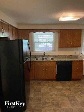 Joliet house for rent - A kitchen with a black fridge and wooden cabinets.