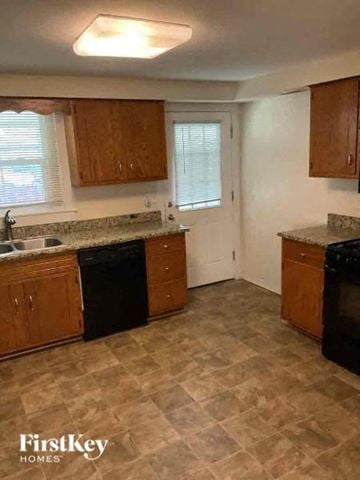 Joliet house for rent - A kitchen with wooden cabinets and black appliances.