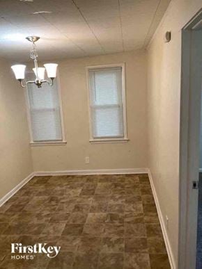 Joliet house for rent - A room with a tiled floor and a chandelier.