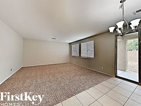 Peoria house for rent - an empty living room with a sliding glass door to the patio