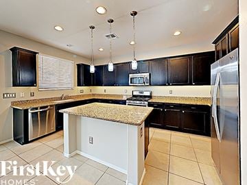 Peoria house for rent - a kitchen with black cabinets and a counter top