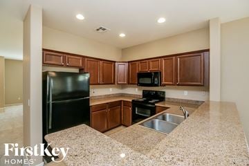 San Tan Valley house for rent - a kitchen with black appliances and granite counter tops