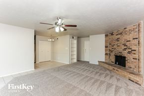 Grand Prairie house for rent - a living room with a brick fireplace and a ceiling fan