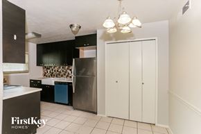 Grand Prairie house for rent - a kitchen with black cabinets and a stainless steel refrigerator