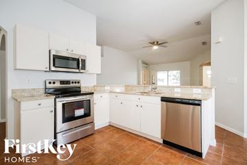 Valrico house for rent - a clean kitchen with white cabinets and stainless steel appliances