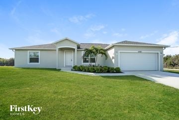 Port Charlotte house for rent - a white house with a lawn and a garage