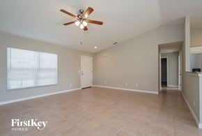 Port Charlotte house for rent - an empty living room with a ceiling fan and a large window