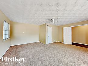 Dallas house for rent - an empty living room with a ceiling fan and a white door