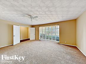 Dallas house for rent - an empty living room with a ceiling fan and a window