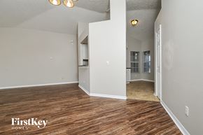 Riverview house for rent - the living room and kitchen of an empty house with wood flooring