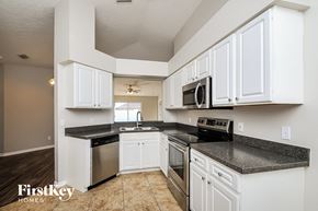 Riverview house for rent - a kitchen with white cabinets and stainless steel appliances