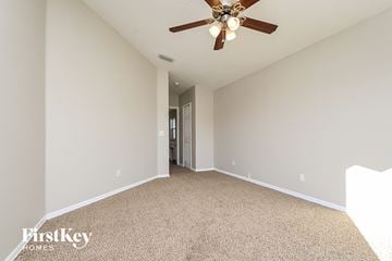 Riverview house for rent - the spacious living room has a ceiling fan and beige carpet