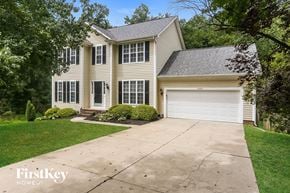 Charlotte house for rent - a white house with a driveway and a white garage door
